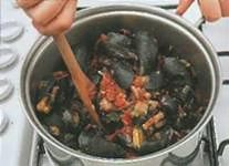 Переложите мидии в томатный соус